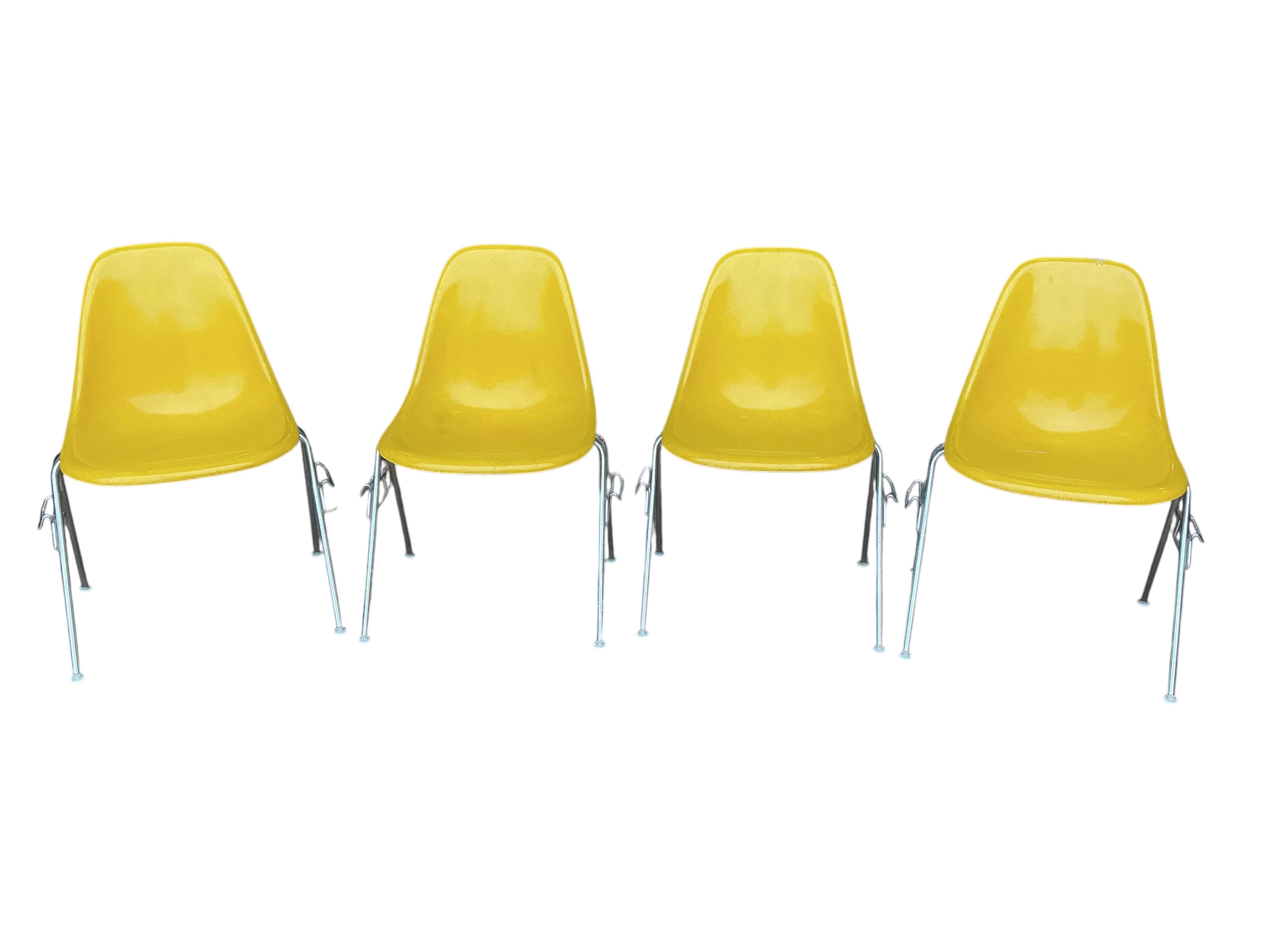 A set of four yellow and chrome Eames shell chairs, width 58cm, height 80cm